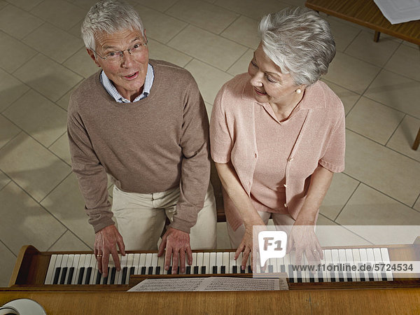 Deutschland  Köln  Seniorenpaar beim Klavierspielen im Pflegeheim