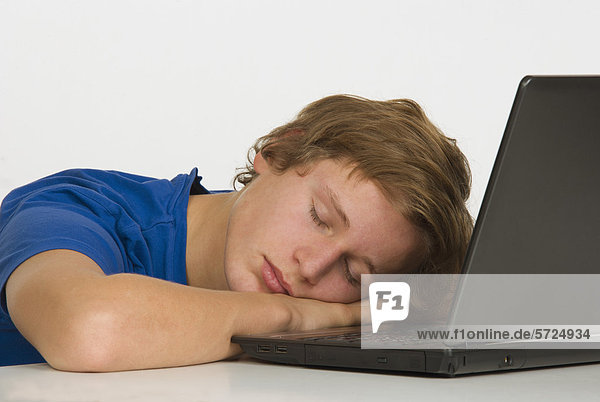 Teenage boy sleeping with laptop