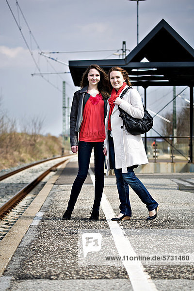 Ein Mädchen und eine Frau auf einem Bahnsteig  Bahnhof