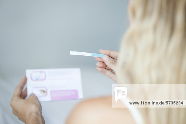 Frau liest Schwangerschaftstest  abgeschnitten
