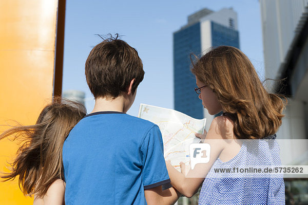 Kinder sehen sich die Karte an  während sie in der Stadt unterwegs sind.