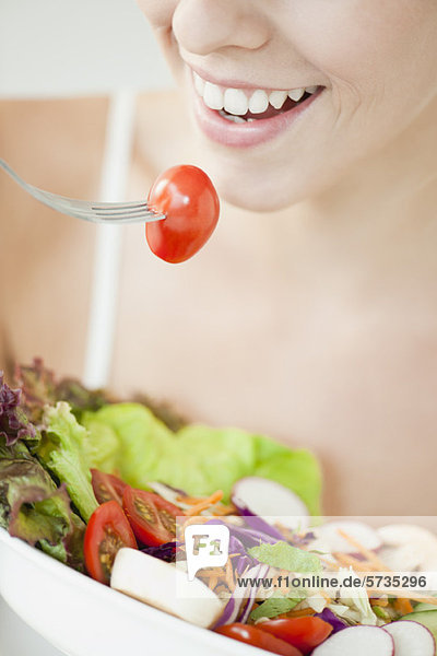 Frau isst Salat  geschnitten
