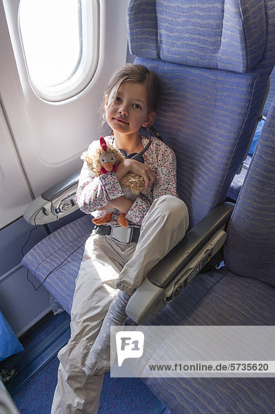 Mädchen mit Plüschtier im Flugzeug  Portrait