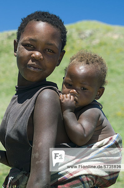 Woman carrying child on her back  Highlands  Kingdom of Lesotho  Africa