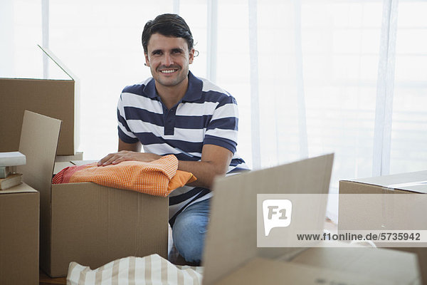 Mid-adult man unpacking in new house