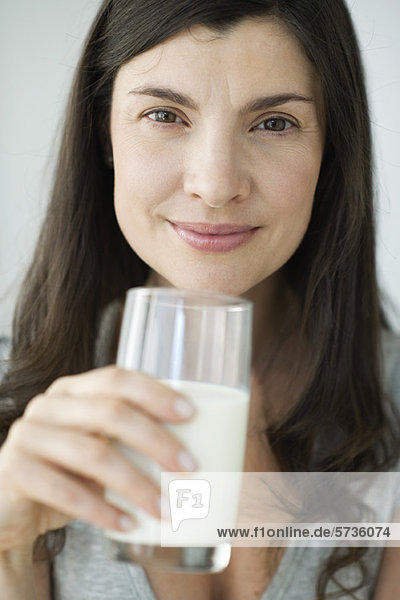 Mittlere erwachsene Frau mit Milchglas