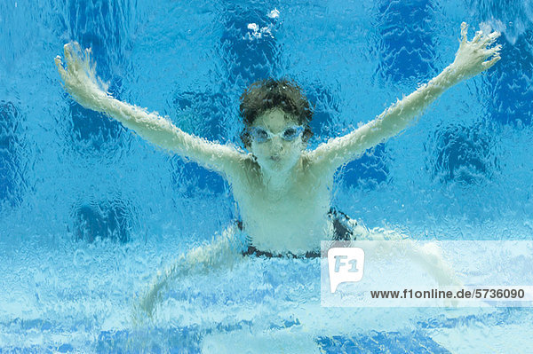Junge schwimmt unter Wasser im Schwimmbad