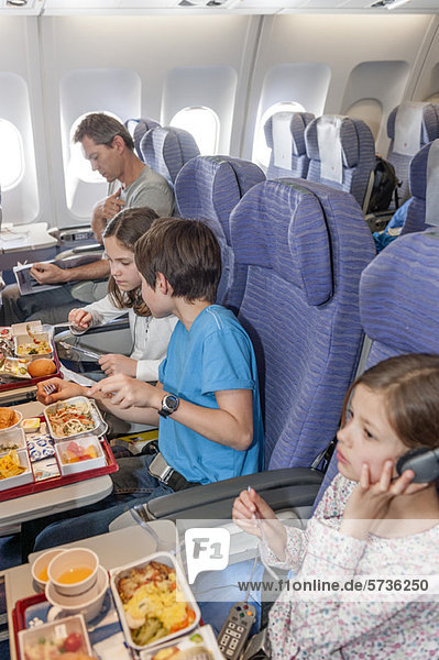 Kinder beim Essen im Flugzeug