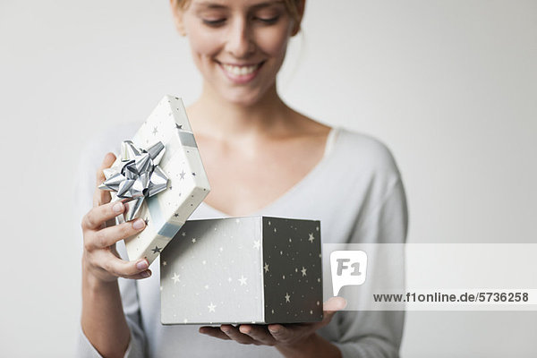 Junge Frau beim Öffnen der Geschenkbox