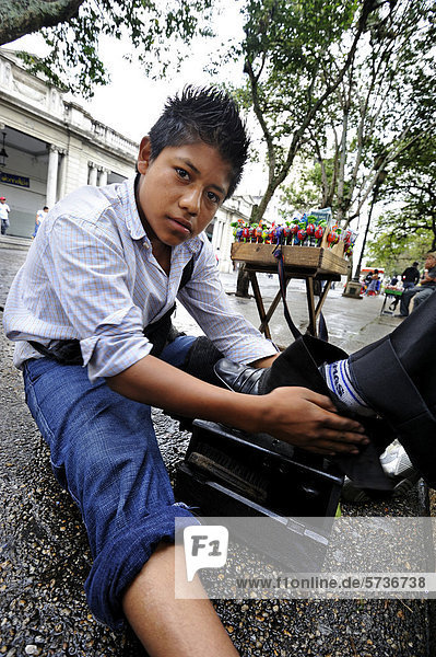 Child labor  shoeshine boy  13 years old  Parque Central  Guatemala City  Guatemala  Central America