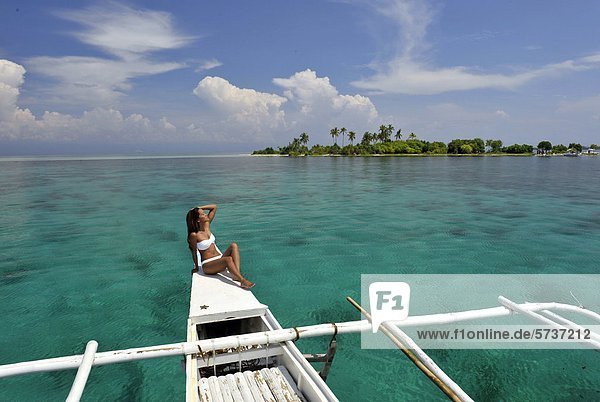 Asien  Philippinen  Bohol  Frau Sonnenbaden am Boot