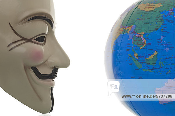 Anonymous-Maske  Guy Fawkes-Maske blickt auf Globus  Symbolbild weltweite Bewegung