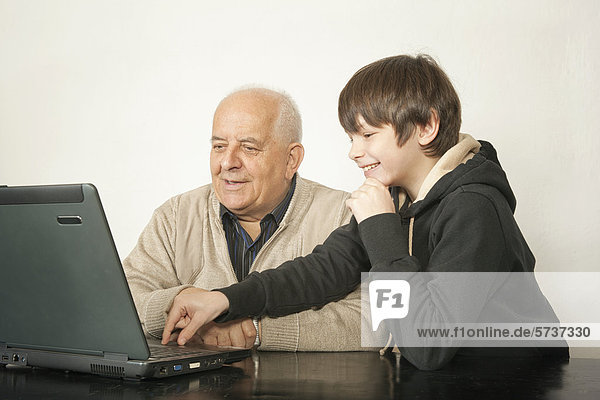 Senior und Junge am Laptop