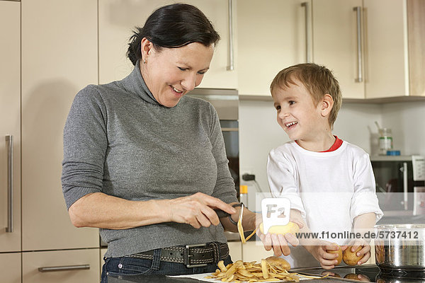 Mutter und Sohn beim Kartoffelschälen
