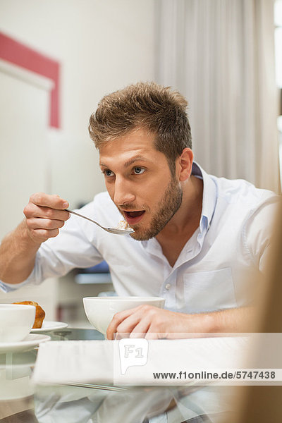 Man eating breakfast at table