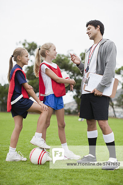 Trainer im Gespräch mit Kindern der Fußballmannschaft