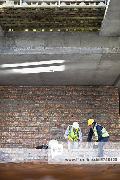 Workers laying brick on site