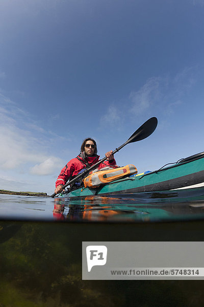 Man kayaking on still lake