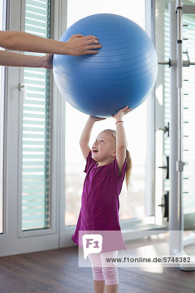 Mädchen beim Spielen mit Übungsball im Fitnessstudio
