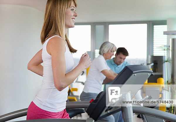 Woman using treadmill in gym