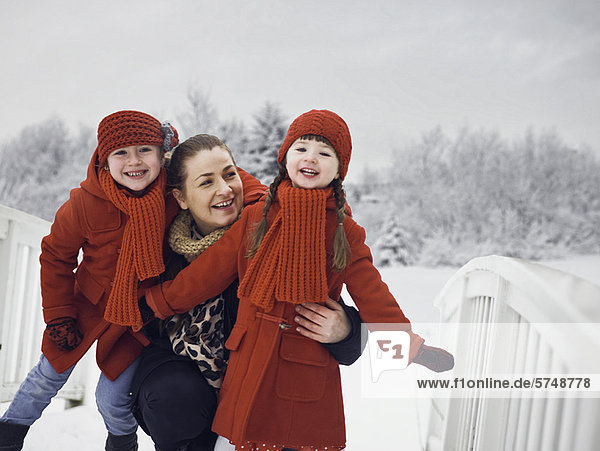 Mother and daughters playing in snow