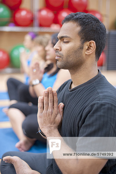 Mann praktiziert Yoga im Studio
