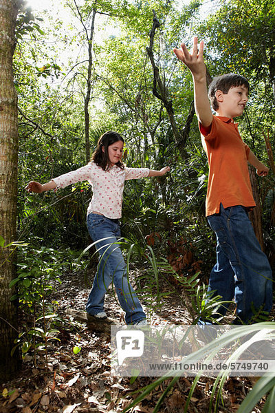 Boy and girl walking through forest