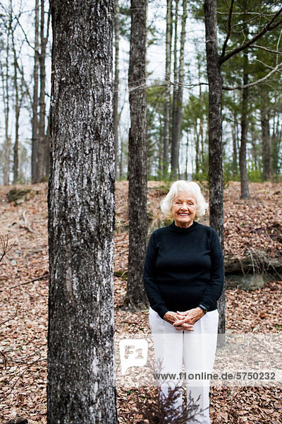 Porträt einer älteren Frau im Wald  Hände umklammert