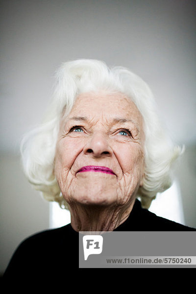 Porträt einer älteren Frau beim Blick nach oben  Studioaufnahme
