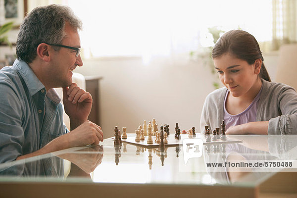 Älterer Mann spielt Schach mit Tochter