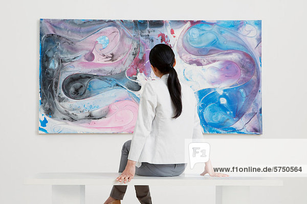 Young woman looking at oil painting in gallery