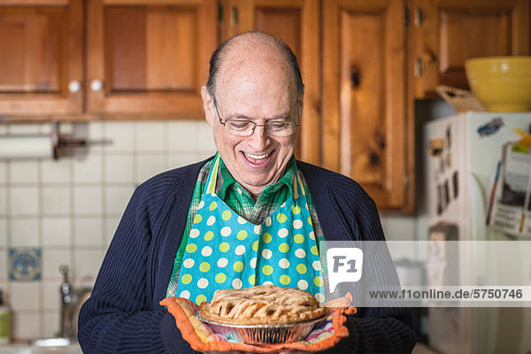 Senior man holding freshly baked pie