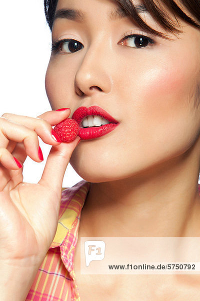 Young woman eating raspberry  portrait