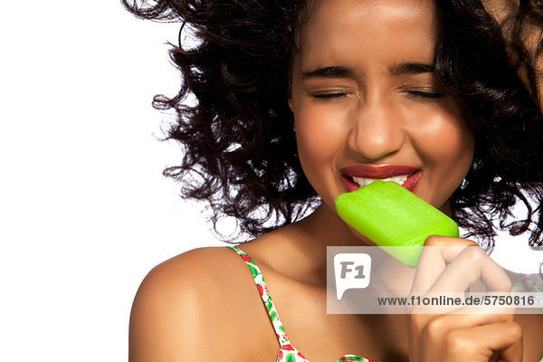 Young Woman eating grün Popsicle mit Augen geschlossen