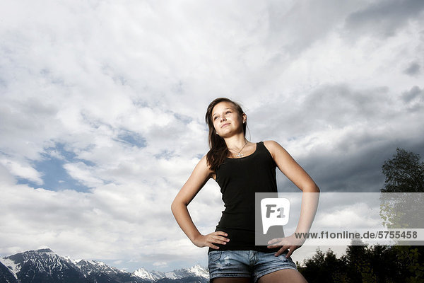 14jähriges Mädchen schaut nachdenklich nach oben  vor Wolkenhimmel  Tirol  Österreich  Europa