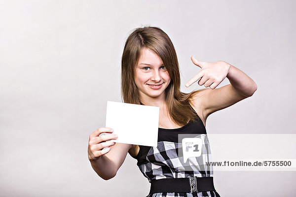 Teenage girl showing blank paper