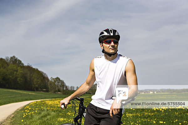 Junger Mann macht eine Pause beim Radfahren