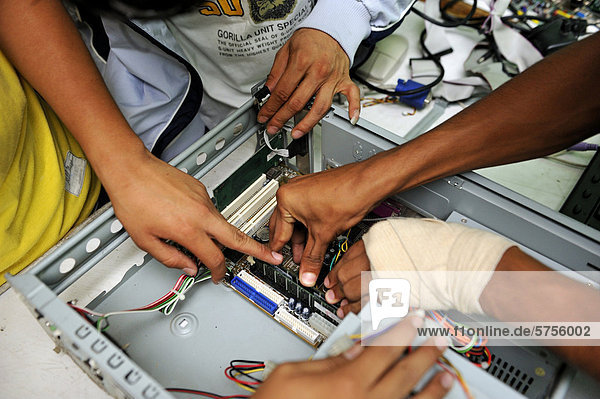 Jugendliche montieren einen Computer  Detailaufnahme