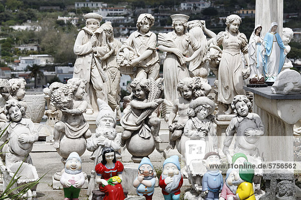 Concrete figures in an open-air exhibition colourful mixture of putti garden gnomes and statues of the Virgin Mary Ischia Island Gulf of Naples Campania Southern Italy Italy Europe