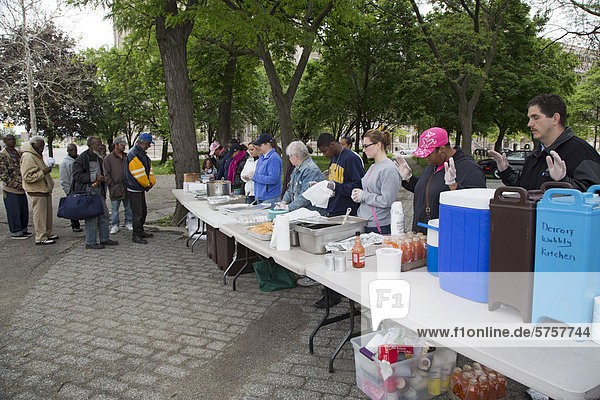 Freiwillige beten vor dem Servieren einer Mahlzeit an Obdachlose im Cass Park die informelle Gruppe bringt alle zwei Wochen Nahrung in den Park Detroit Michigan USA