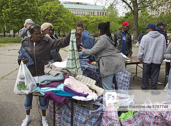 Volunteers from United Christians in Christ church distribute clothing to homeless people in Cass Park  Detroit  Michigan  USA