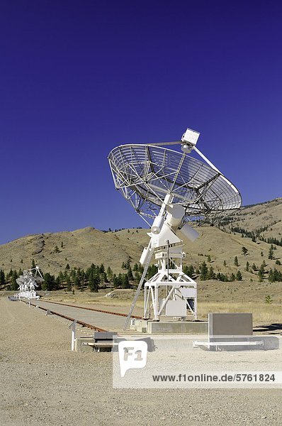 Eine große Satellitenschüssel mit drei im Hintergrund am Dominion Radio-Observatorium in der Nähe von Okanagan Falls  BC. Vertikal.