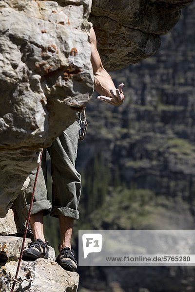 Ein Rockclimber schüttelt sich seine Unterarme beim Klettern am Lake Louise  AB