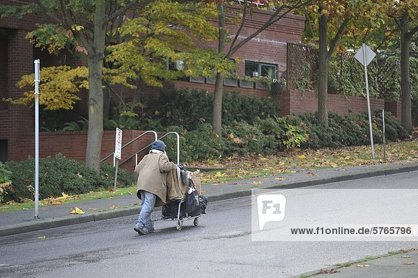 Old man pushing shopping cart on Gilford Street  Vancouver  British Columbia  Canada