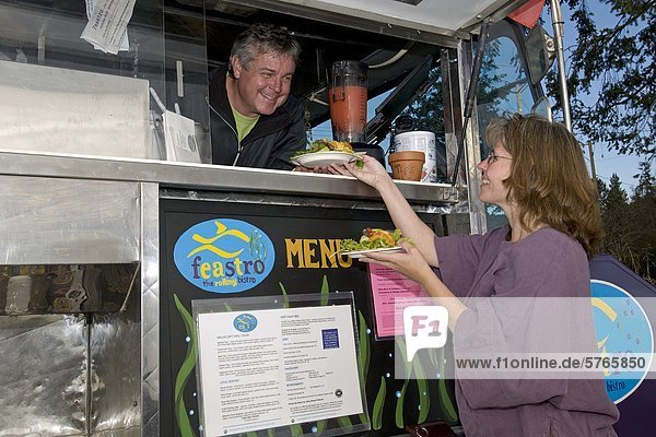 Ein Anbieter verkauft Lebensmittel an eine Frau von einer mobilen Küche in Sechelt  British Columbia  Sunshine Coast Vancouver Küste und die Berge Region  Kanada