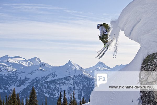 A male skier airs off a snow pillow while on a cat ski trip. Monashee Mountains  Britsh Columbia  Canada