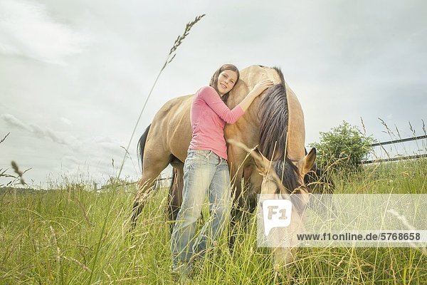 Mädchen und Paint Horse auf der Weide  Traishof  Königsbach-Stein  Baden-Württemberg  Deutschland  Europa