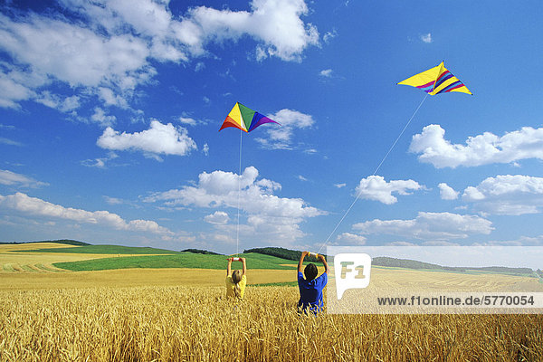 Children kite flying in wheat field  Tiger Hills  Manitoba  Canada