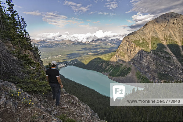 Hiker on top of the Big Beehive mountain over looking Lake Louise in Banff National Park  Alberta  Canada.