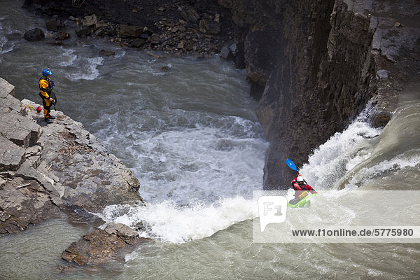 A male kayaker drops a large waterfall on the Bighorn River  Nordegg  Alberta  Canada